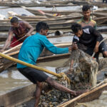 Even though their work is very tough, a couple of young Bangladeshi stone miners make jokes while hauling rocks (image by Yousuf Tushar)