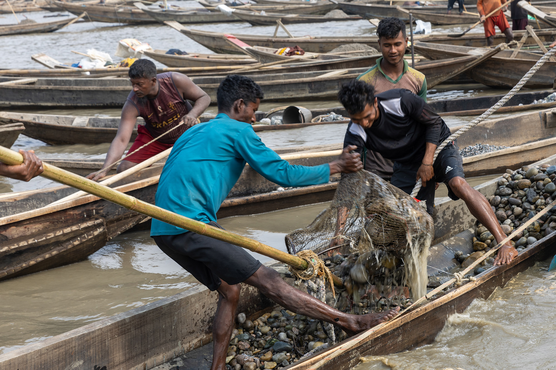 Even though their work is very tough, a couple of young Bangladeshi stone miners make jokes while hauling rocks (image by Yousuf Tushar)