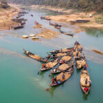 Sand mining boats line up to be loaded on a remote river in Bangladesh (image by Yousuf Tushar)
