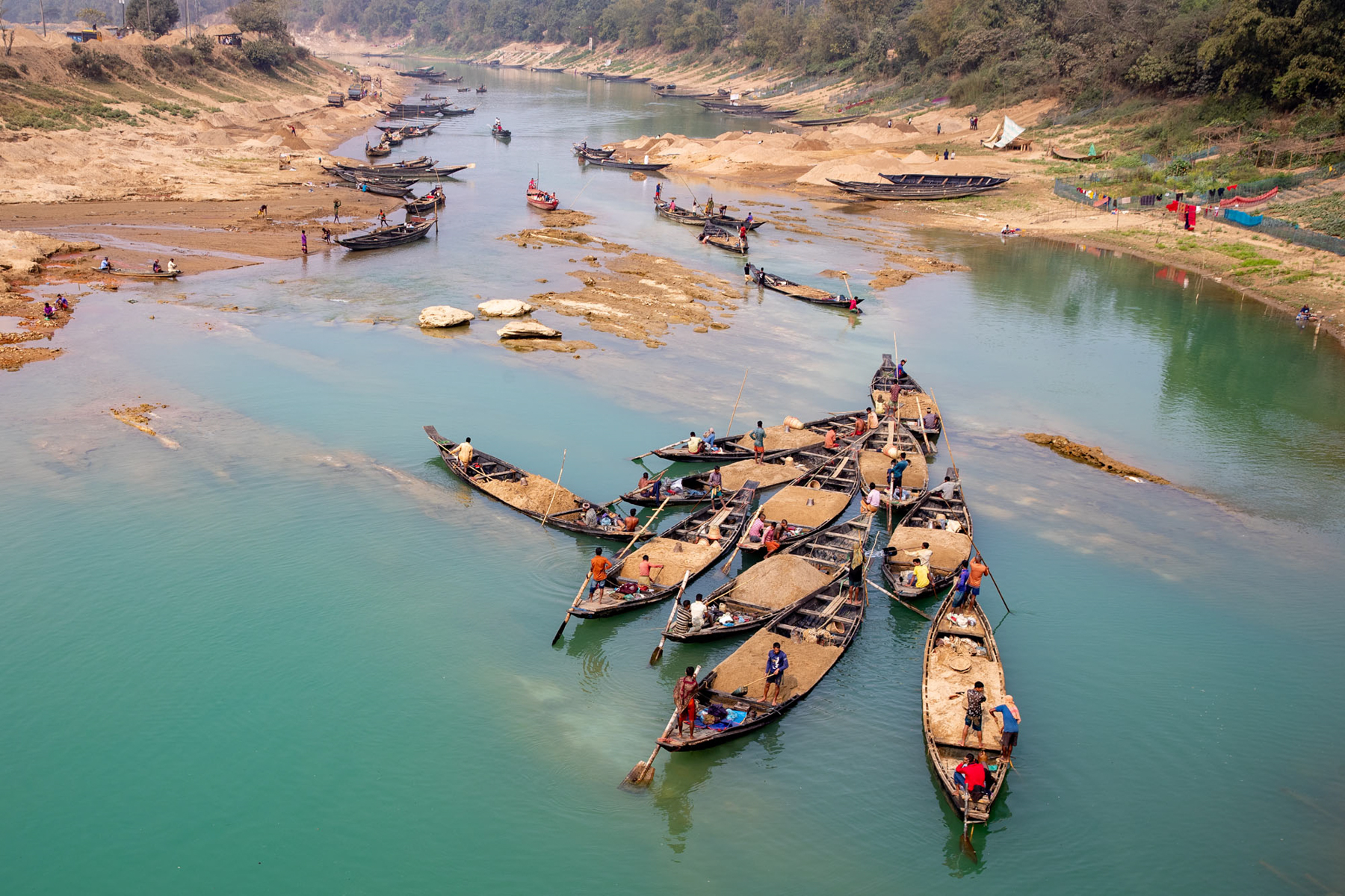 Sand mining boats line up to be loaded on a remote river in Bangladesh (image by Yousuf Tushar)