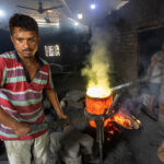 Workers sweat in the tremendous heat from a blast furnace used to melt down broken ships in Dhaka (image by Yousuf Tushar)