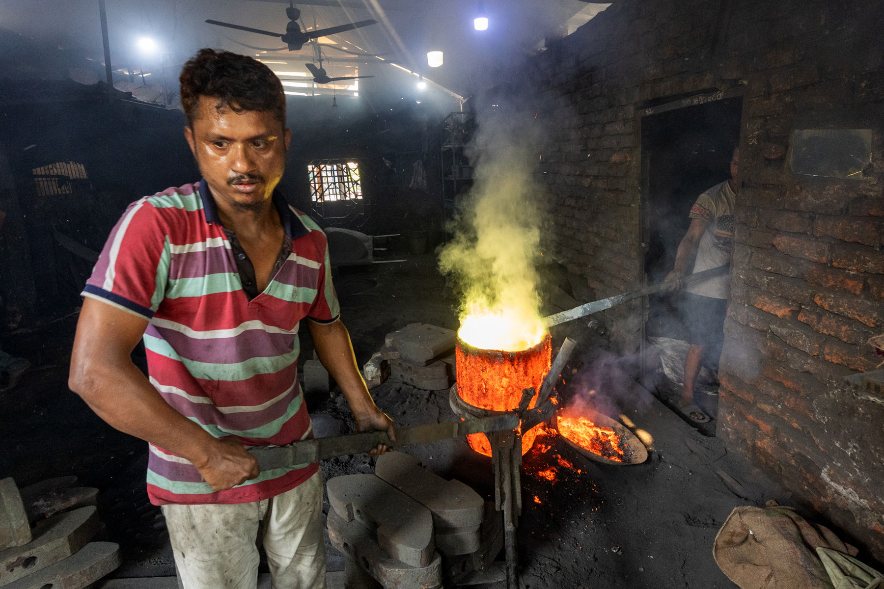Workers sweat in the tremendous heat from a blast furnace used to melt down broken ships in Dhaka (image by Yousuf Tushar)