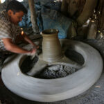 Spinning the wheel in a local pottery making facility (image by Yousuf Tushar)