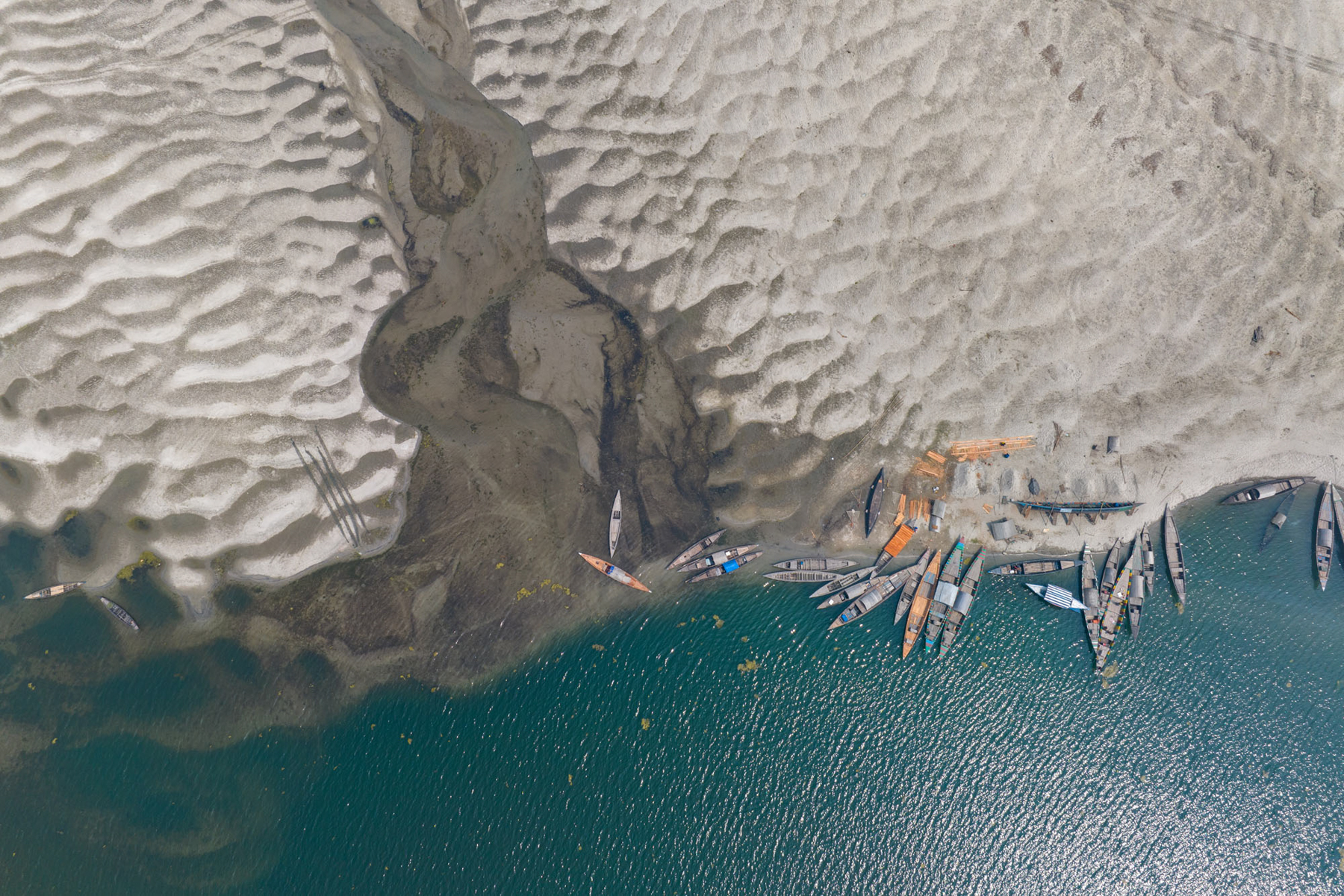 Aerial view of riverboats at the mouth of a tributary (image by Yousuf Tushar)