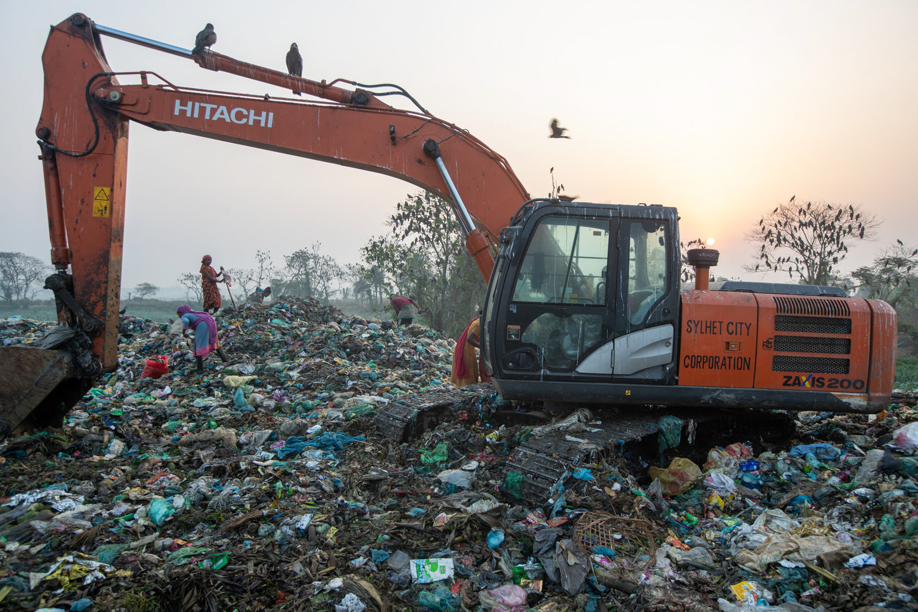 Waste workers in Sylhet are assisted by large machine diggers (image by Yousuf Tushar)