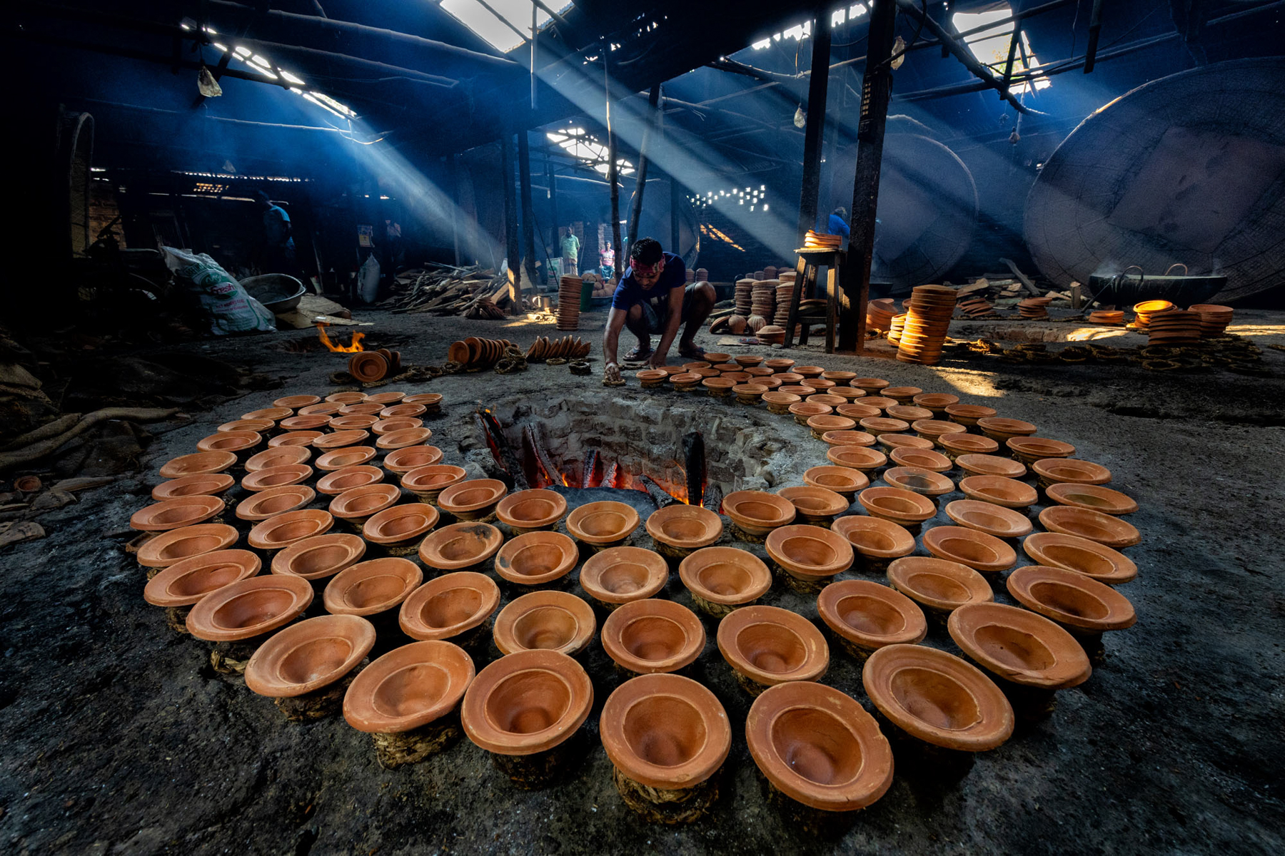 Shards of light pierce the floor of a yoghurt making factory in remote Bangladesh (image by Yousuf Tushar)