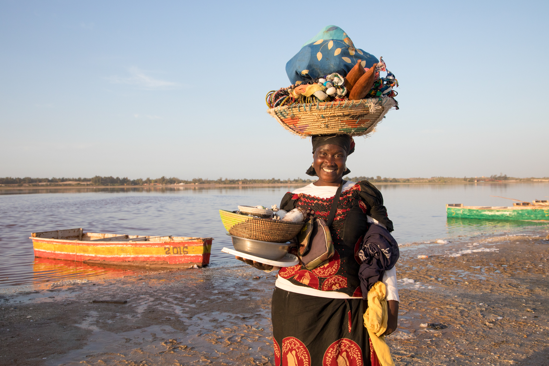 Smiling souvenir seller on the shores of Lac Rose. (image by Inger Vandyke)