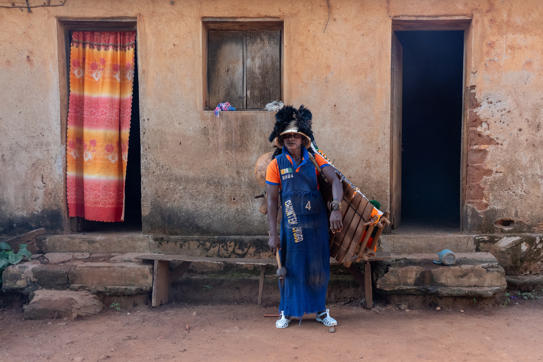 A Balafon Player outside his home (image by Inger Vandyke)
