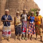Batammariba women from Togo after a ceremony in front of a tata, wearing traditional hats decorated with cowrie shells and antelope horns (image by Ingrid Koedood)