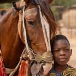 A young boy caring for the horse. Perhaps a future Batonu horseman, carrying tradition into the next generation (image by Ingrid Koedood)