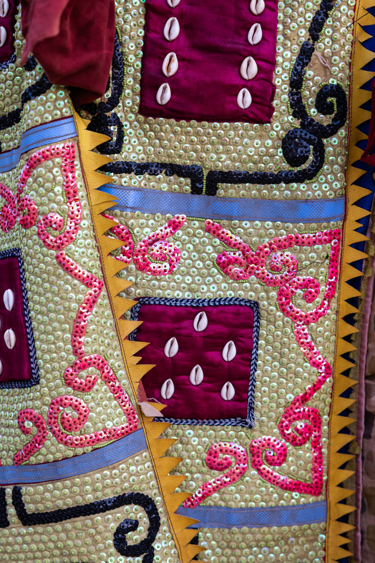Close up: hand-embroided fabric of an Egungun costume, rich in symbols and color (image by Ingrid Koedood)