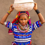 Portrait of a young Fulani woman carrying calabashes on her head (image by Ingrid Koedood)