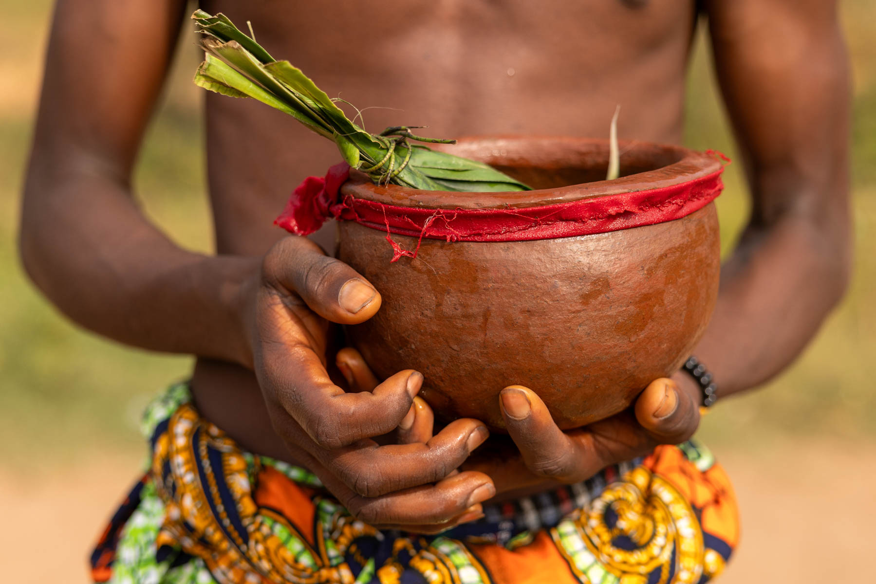 During the Gounouko mask ceremony a young man sprinkled water from a pot as ritual blessing, to purify and protect the ceremony (image by Ingrid Koedood)