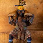 A Guèlèdè performer poses with a young boy. Shy at first, but proud to be part of the moment (image by Ingrid Koedood)