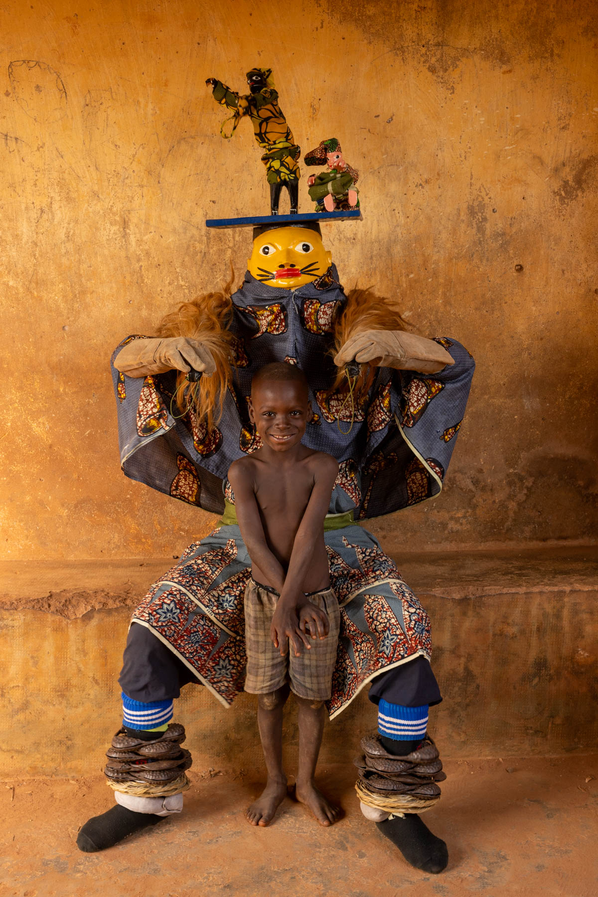 A Guèlèdè performer poses with a young boy. Shy at first, but proud to be part of the moment (image by Ingrid Koedood)