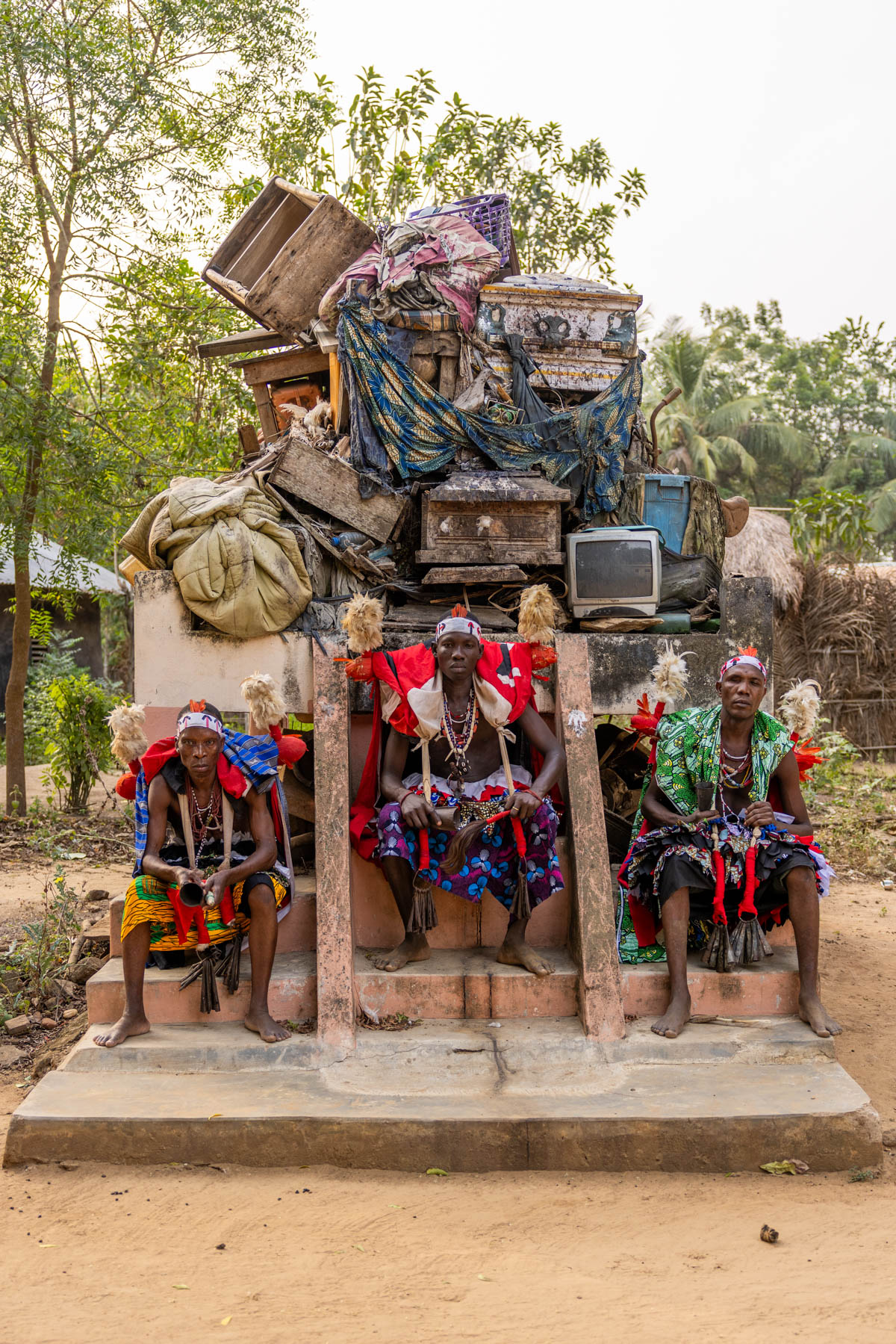 Heviosso Shamans. Heviosso is a powerful Vodun deity associated with thunder, lightning and fire. He is believed to protect the community, punish wrongdoing, and bring justice. They are seated in front of the alter where they expose the bodies and belongings of the bad people killed by the Heviosso (image by Ingrid Koedood)