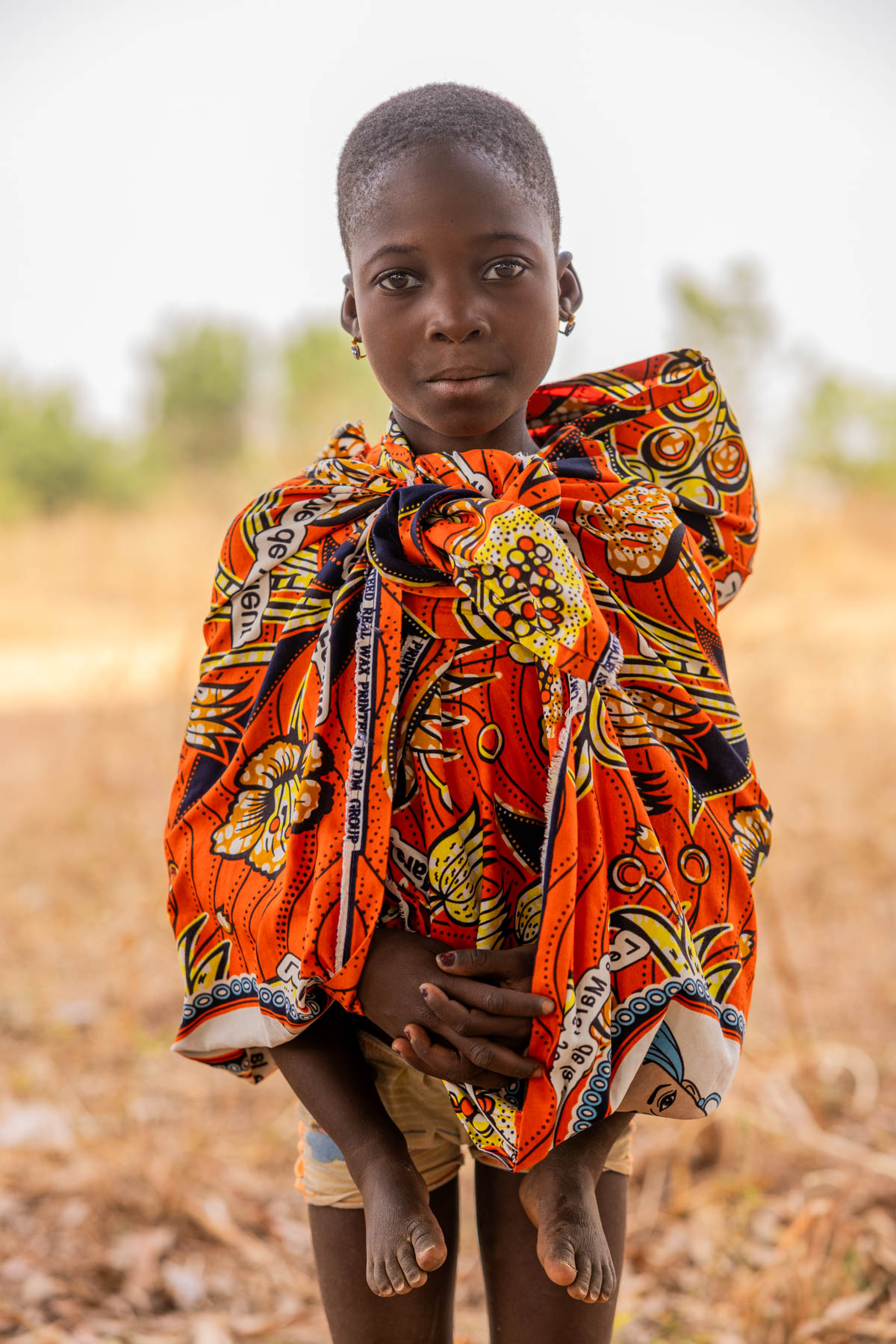 A young Otamari girl with a baby on her back. Even the youngest carry big responsibilities (image by Ingrid Koedood)