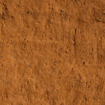 The textured wall of a tata. A UNESCO recognized earthen home, echoing the same lines of identity worn in the face by the Otamari people (image by Ingrid Koedood)