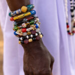 Dressed in white, adorned with colorful beads and bracelets (image by Ingrid Koedood)