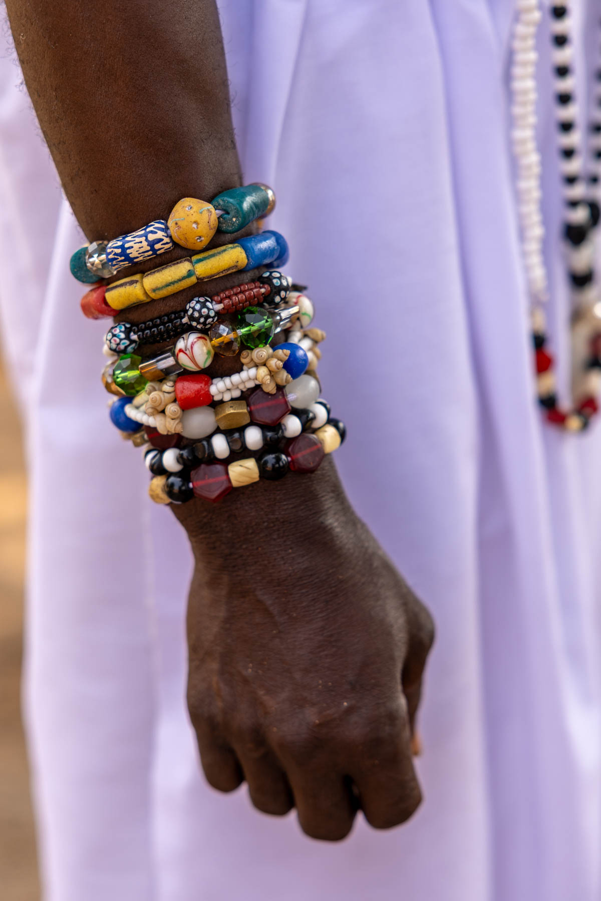 Dressed in white, adorned with colorful beads and bracelets (image by Ingrid Koedood)