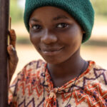 A young woman during Vodun Day, wearing a winter beanie despite the warm Beninese sun (image by Ingrid Koedood)