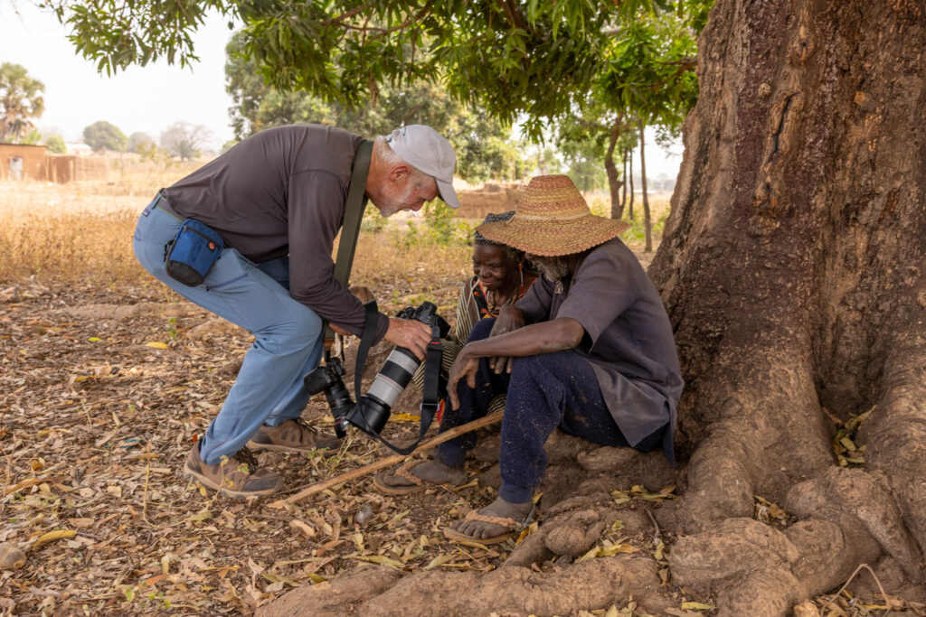 A moment of connection under the trees. Stu sharing his image with the Otamari people (image by Ingrid Koedood)