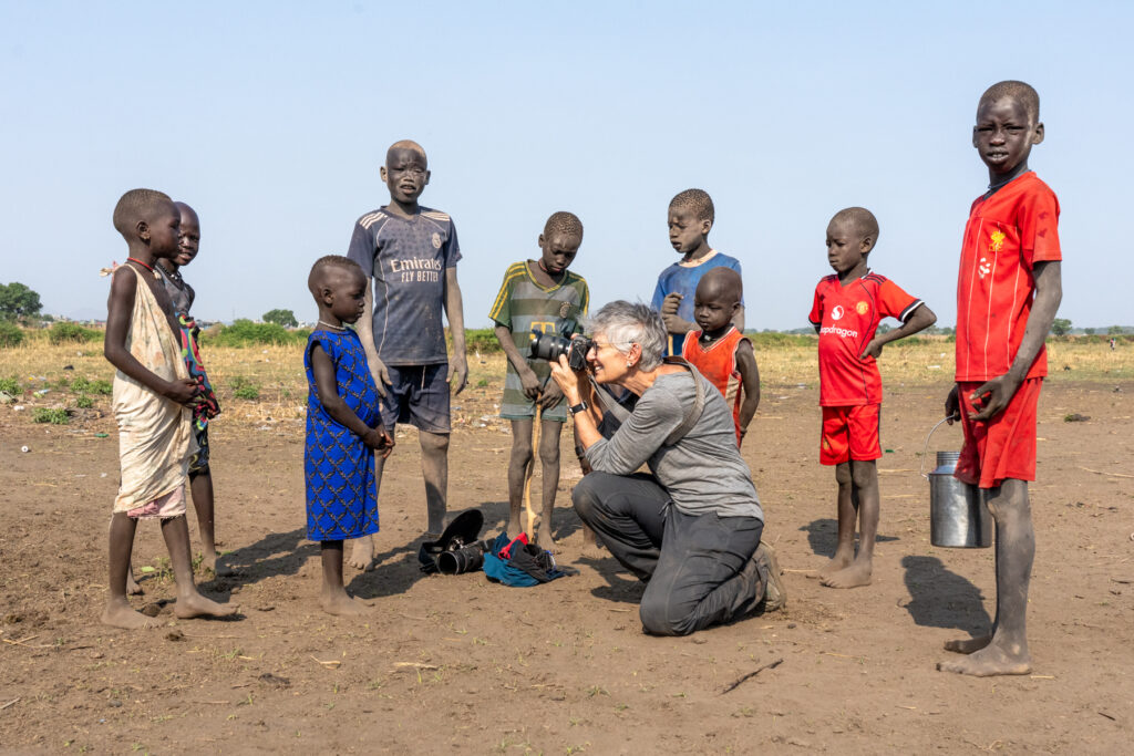 Amy photographing Mundari kids at a ceremony (image by Inger Vandyke)