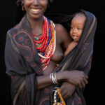 Carried close, where warmth meets wonder. A moment between an Arbore mother and her child. (image by Ingrid Koedood)