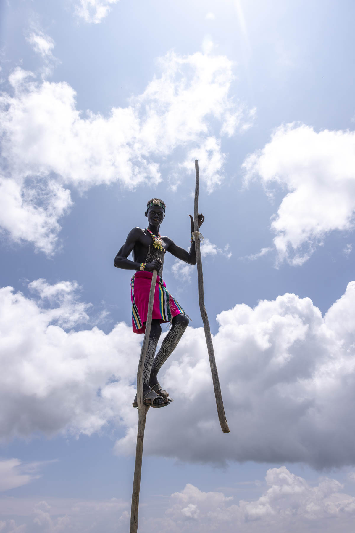 A Banna boy on stilts, rising above the earth, for a moment, it feels as if he is playing among the clouds. (image by Ingrid Koedood)