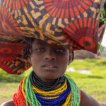 Balance and color, a Dassanech girl carrying her load. (image by Ingrid Koedood)