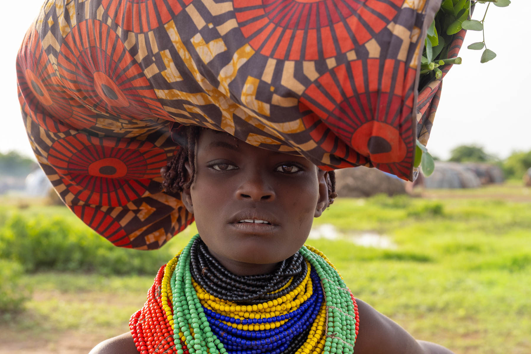Balance and color, a Dassanech girl carrying her load. (image by Ingrid Koedood)