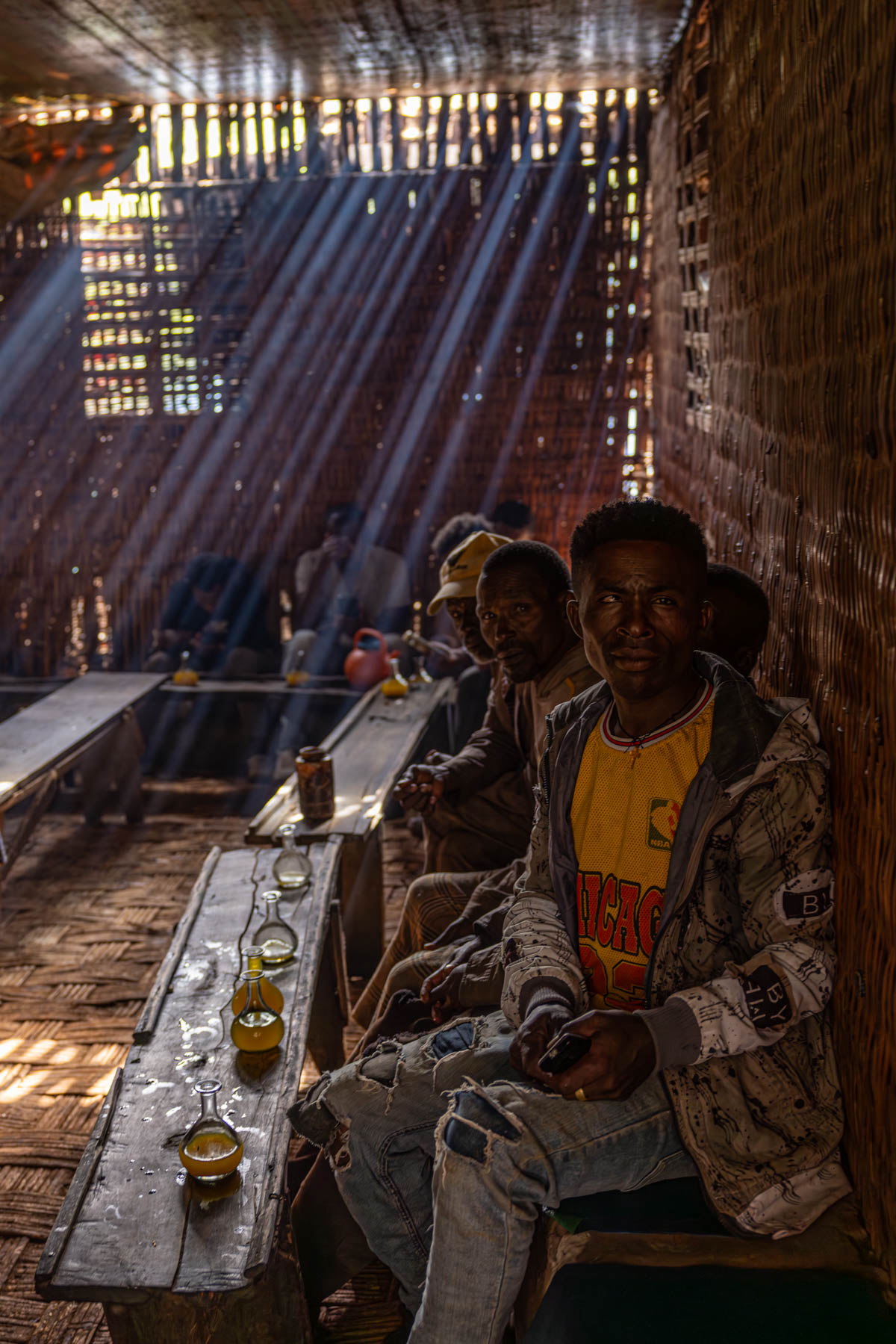 Men gathering in a Tej (honey wine) bar in Dorze, sharing honey wine. (image by Ingrid Koedood)