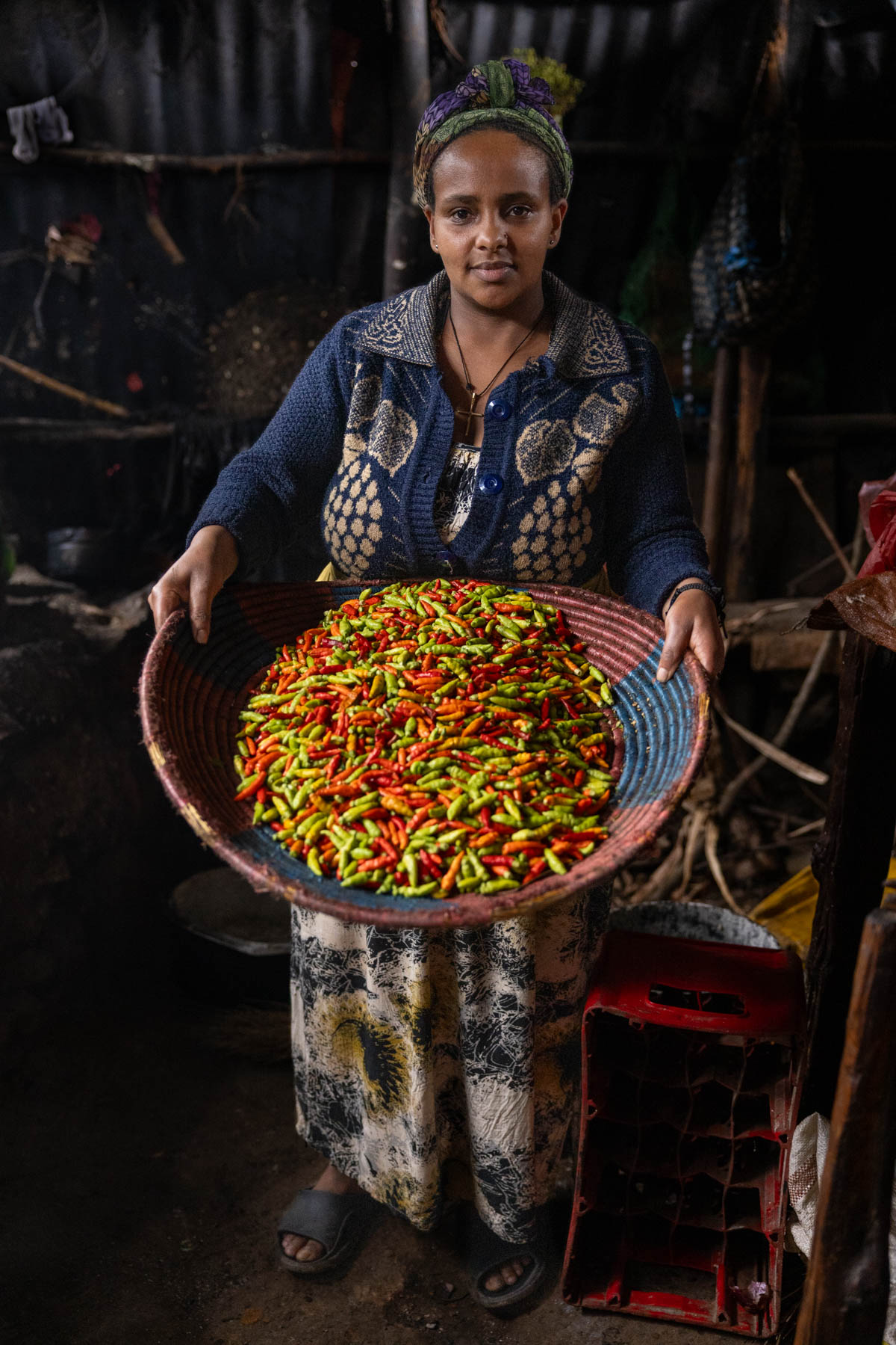 Woman showing colorful peppers in a kitchen in Dorze. (image by Ingrid Koedood)