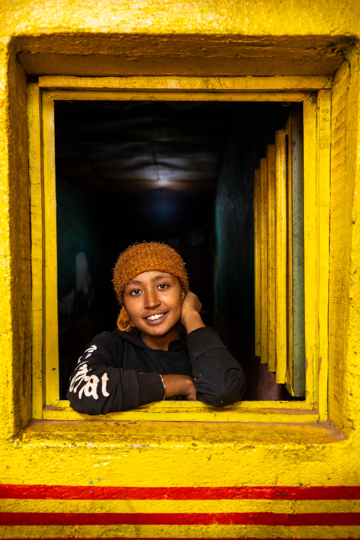 Portrait of a young woman posing in a window of a bar in Dorze (image by Ingrid Koedood)