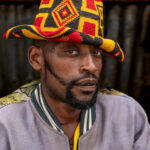 Portrait of a man in front of a honey wine bar in Dorze, wearing a traditional hat. (image by Ingrid Koedood)