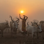 A Mundari man holds his hands in the air in the shape of his favourite cow (image by Inger Vandyke)