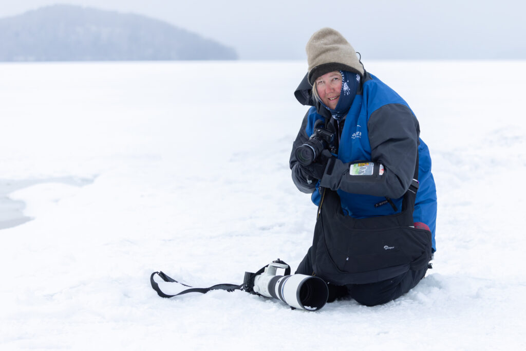 Judy braves the icy cold to photograph Lake Kussharo’s Whooper Swans (Image by Mike Watson)