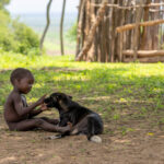 A tender moment between a young Kara boy and his dog. (image by Ingrid Koedood)