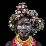 Creativity in every detail, a Kara woman wearing a headdress of bottle caps. (image by Ingrid Koedood)