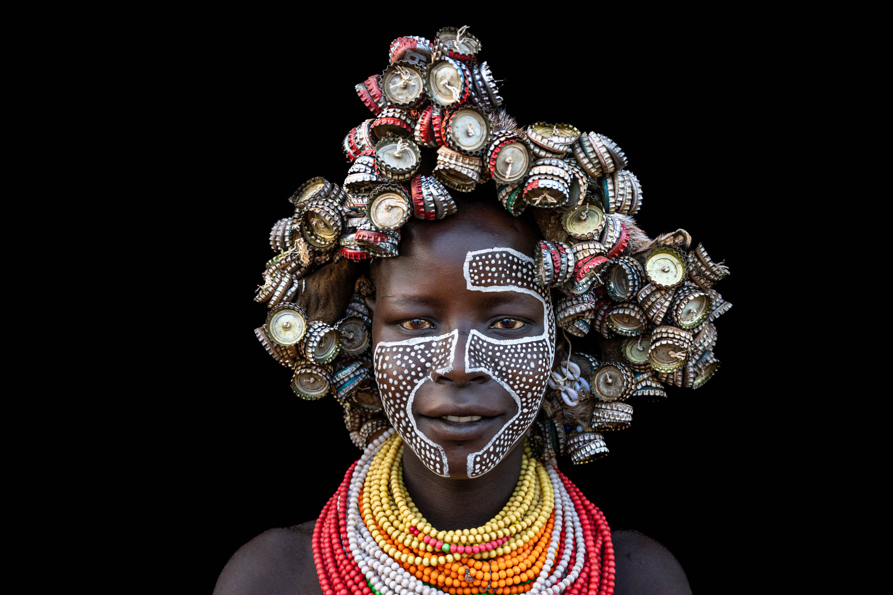 Creativity in every detail, a Kara woman wearing a headdress of bottle caps. (image by Ingrid Koedood)