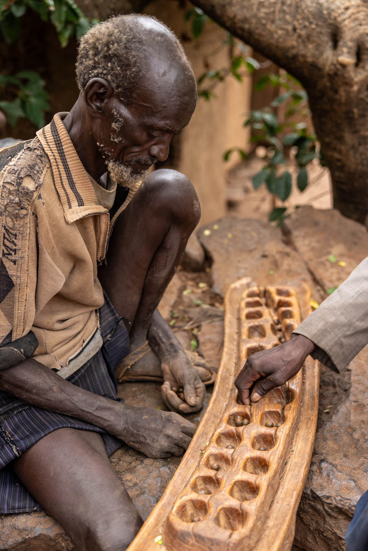 Two men playing gebeta, a traditional Ethiopean mancala game. (image by Ingrid Koedood)
