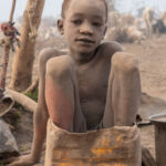 Tiny Mundari boy in a bucket (image by Inger Vandyke)