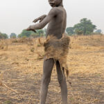 Mundari boy wearing the skin of an Egyptian Mongoose (image by Inger Vandyke)