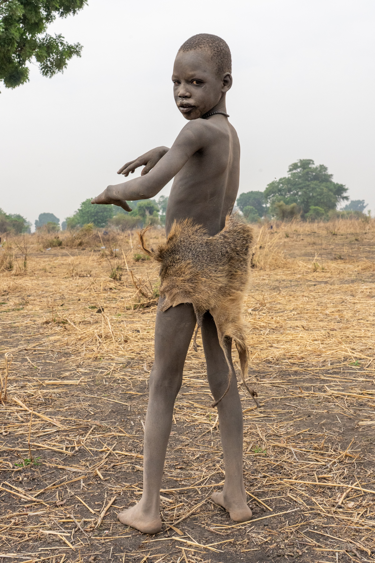 Mundari boy wearing the skin of an Egyptian Mongoose (image by Inger Vandyke)