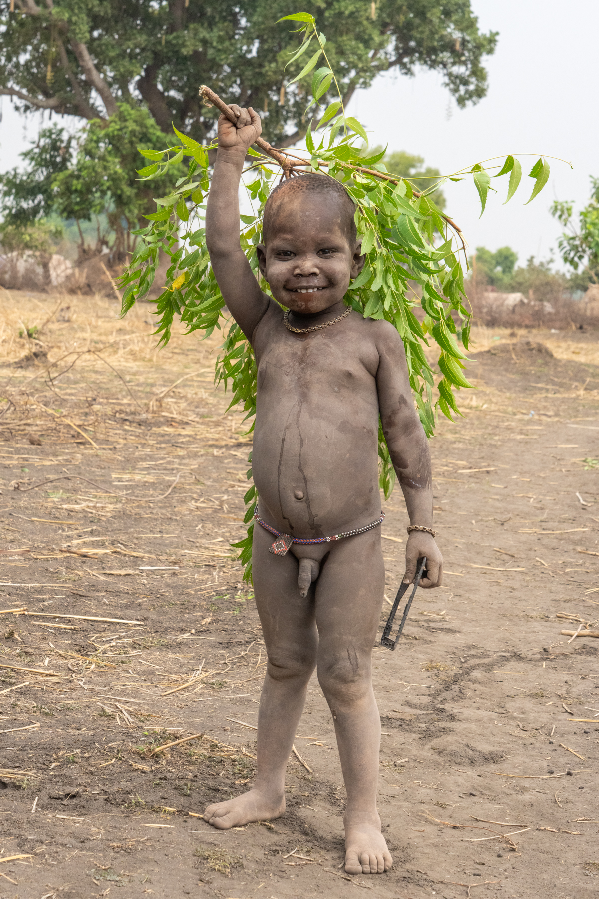 Sweet Mundari boy with a tree branch which will be used as the camp broom (image by Inger Vandyke)