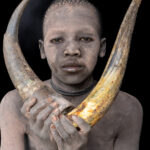 Young Mundari boy with cow horns (image by Inger Vandyke)