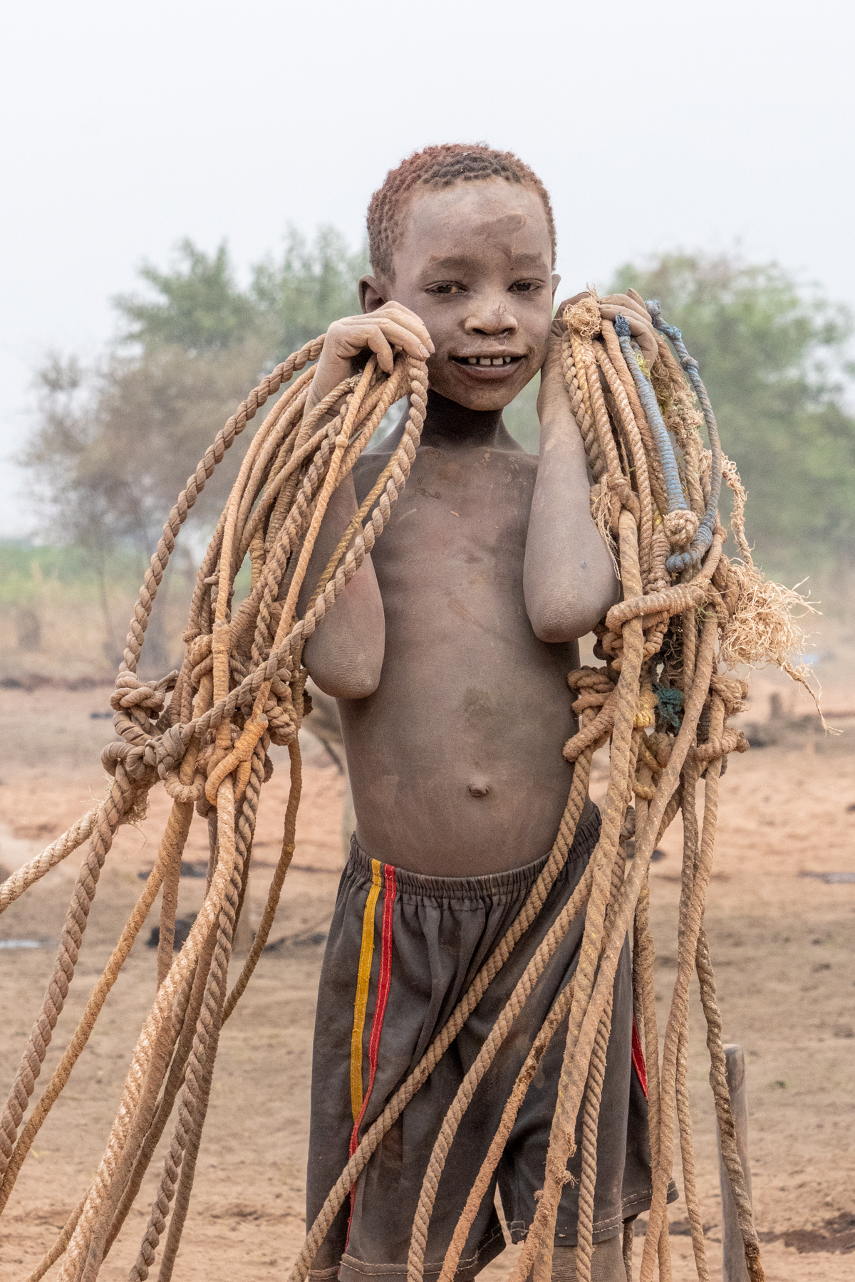 Smiling Mundari boy with tethering ropes (image by Inger Vandyke)
