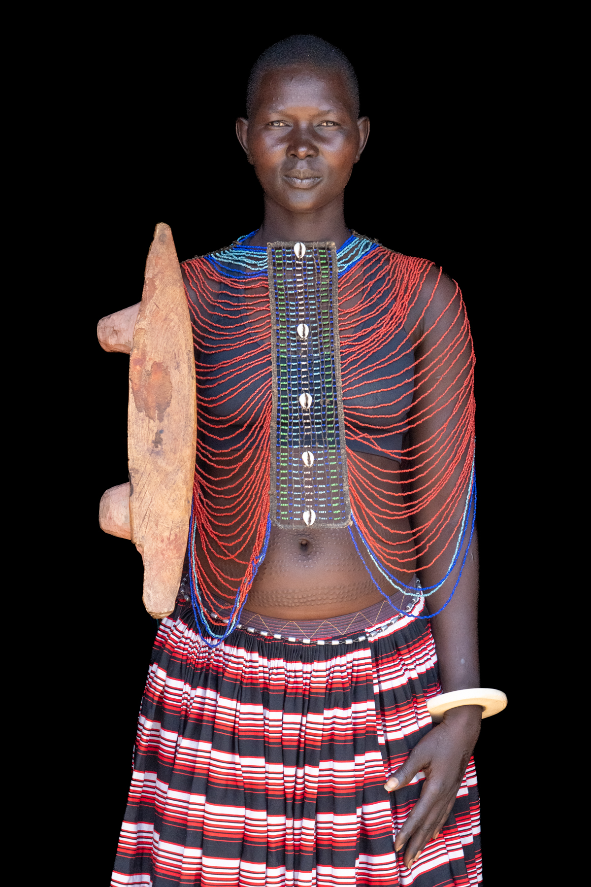 Beautiful Mundari woman wearing her bone bracelet, beaded collar and carring a hand-carved wooden seat (image by Inger Vandyke)