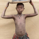 Mundari girl carrying washing bowl (image by Inger Vandyke)