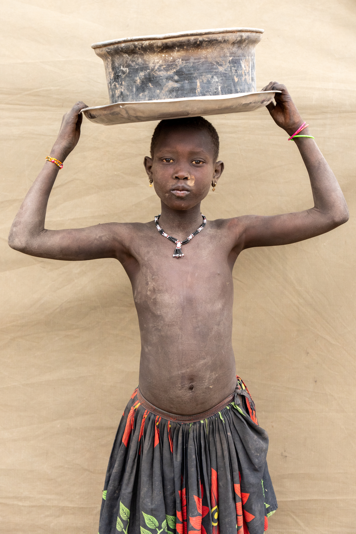 Mundari girl carrying washing bowl (image by Inger Vandyke)